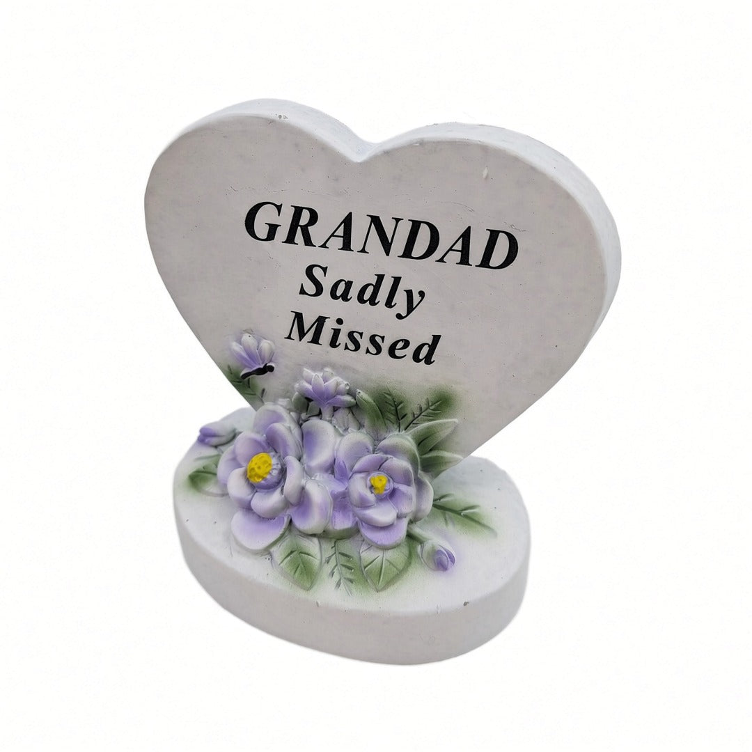 Grandad Sadly Missed white heart memorial with purple flowers close up