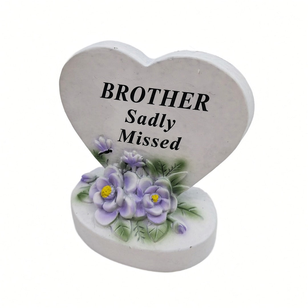 Brother Sadly Missed white heart memorial with purple flowers close up