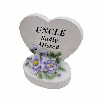Uncle Sadly Missed white heart memorial with purple flowers close up